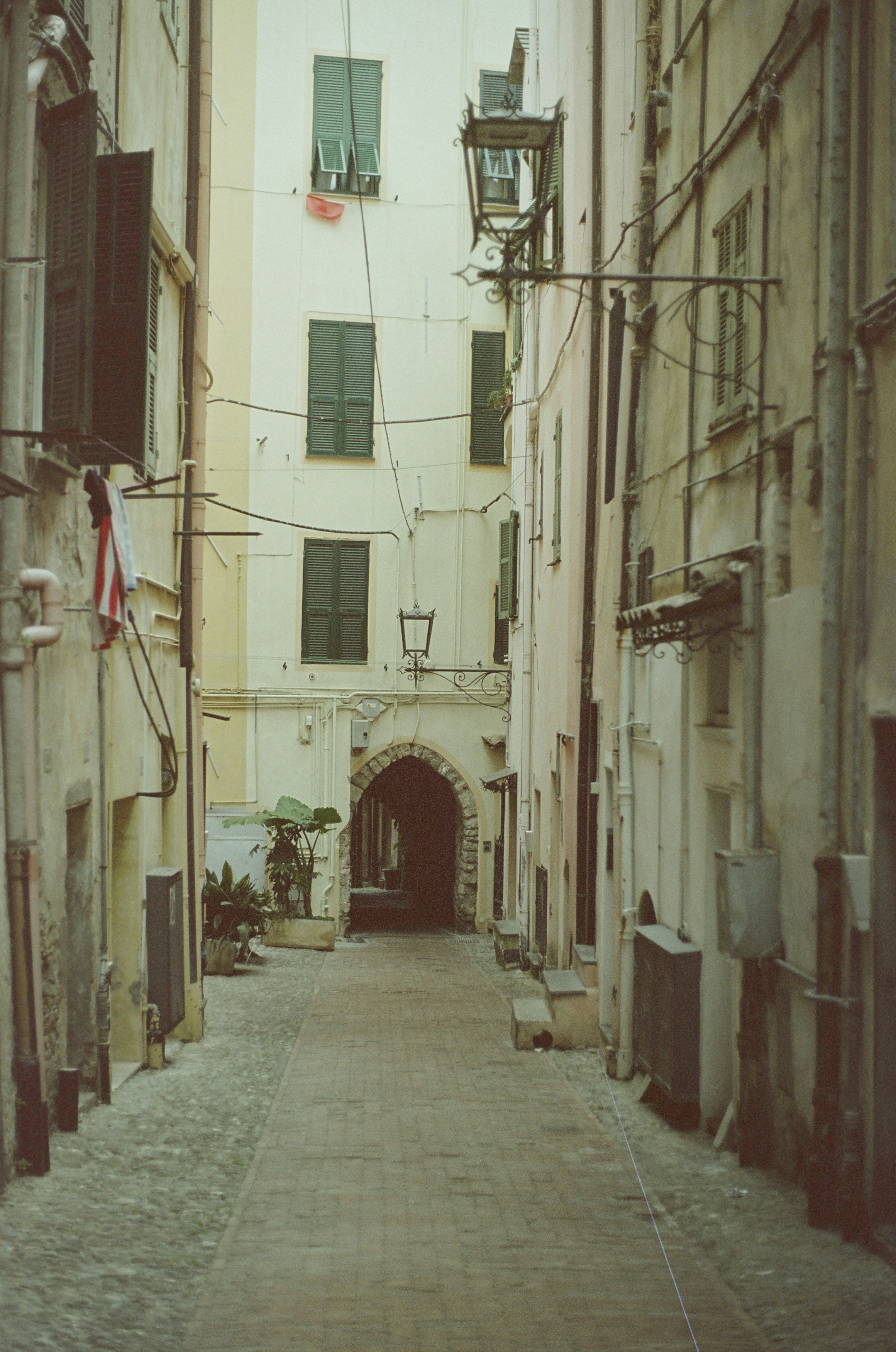 a narrow alley way with a clock tower in the distance