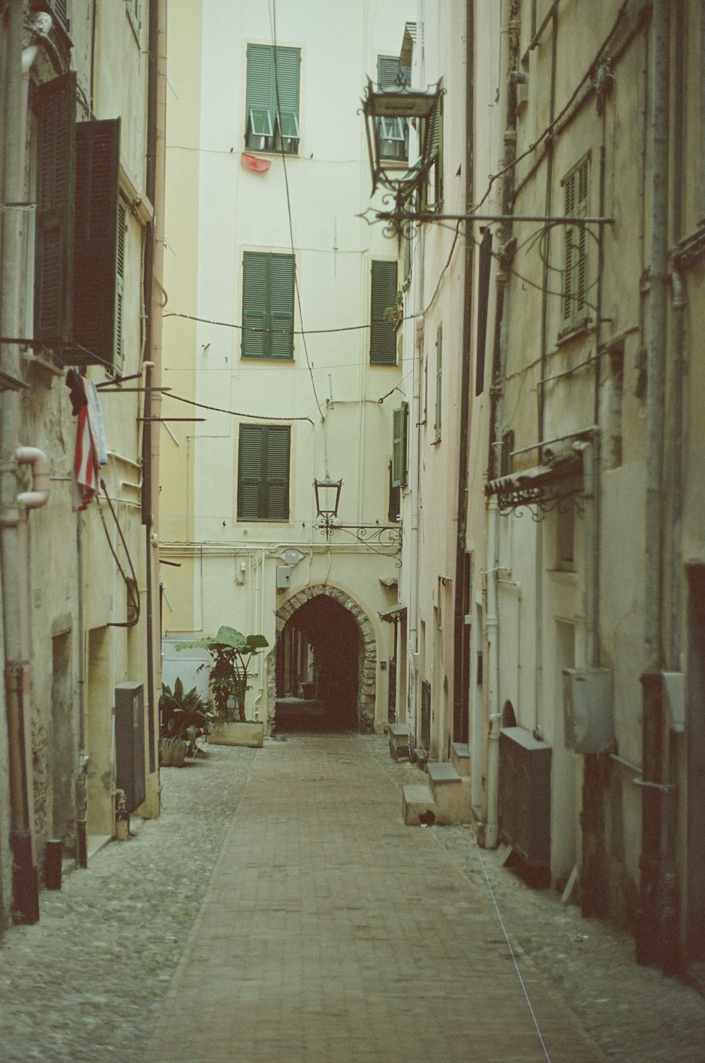 a narrow alley way with a clock tower in the distance