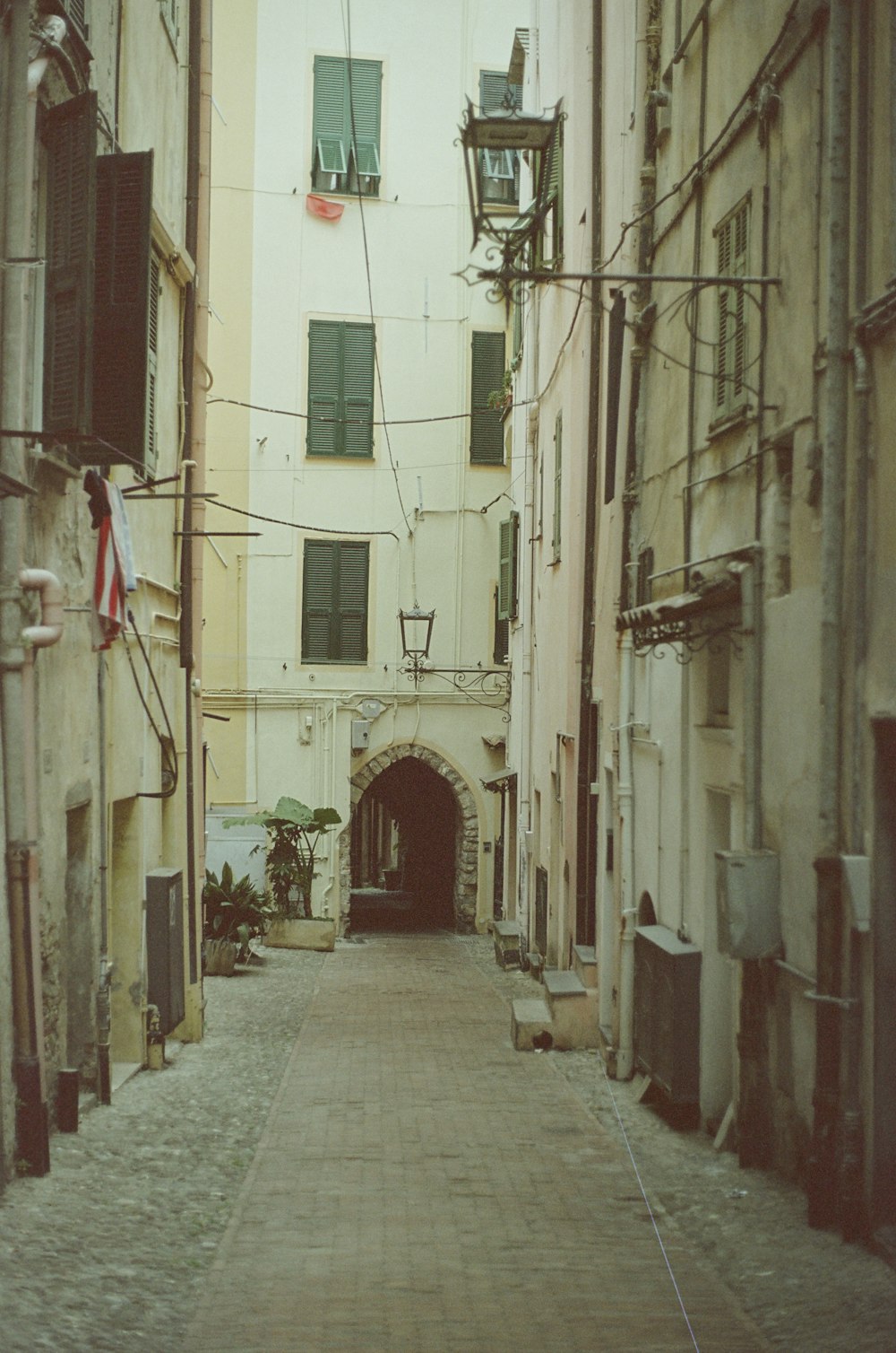 une ruelle étroite avec une tour de l’horloge au loin