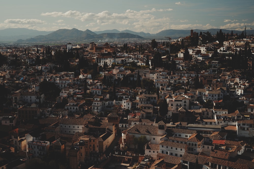 an aerial view of a city with mountains in the background