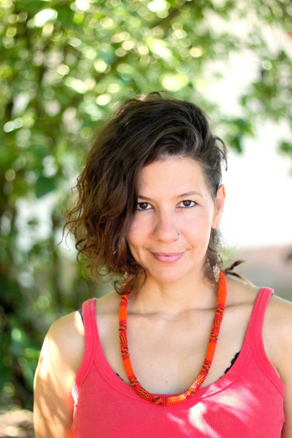 a woman in a pink tank top is smiling