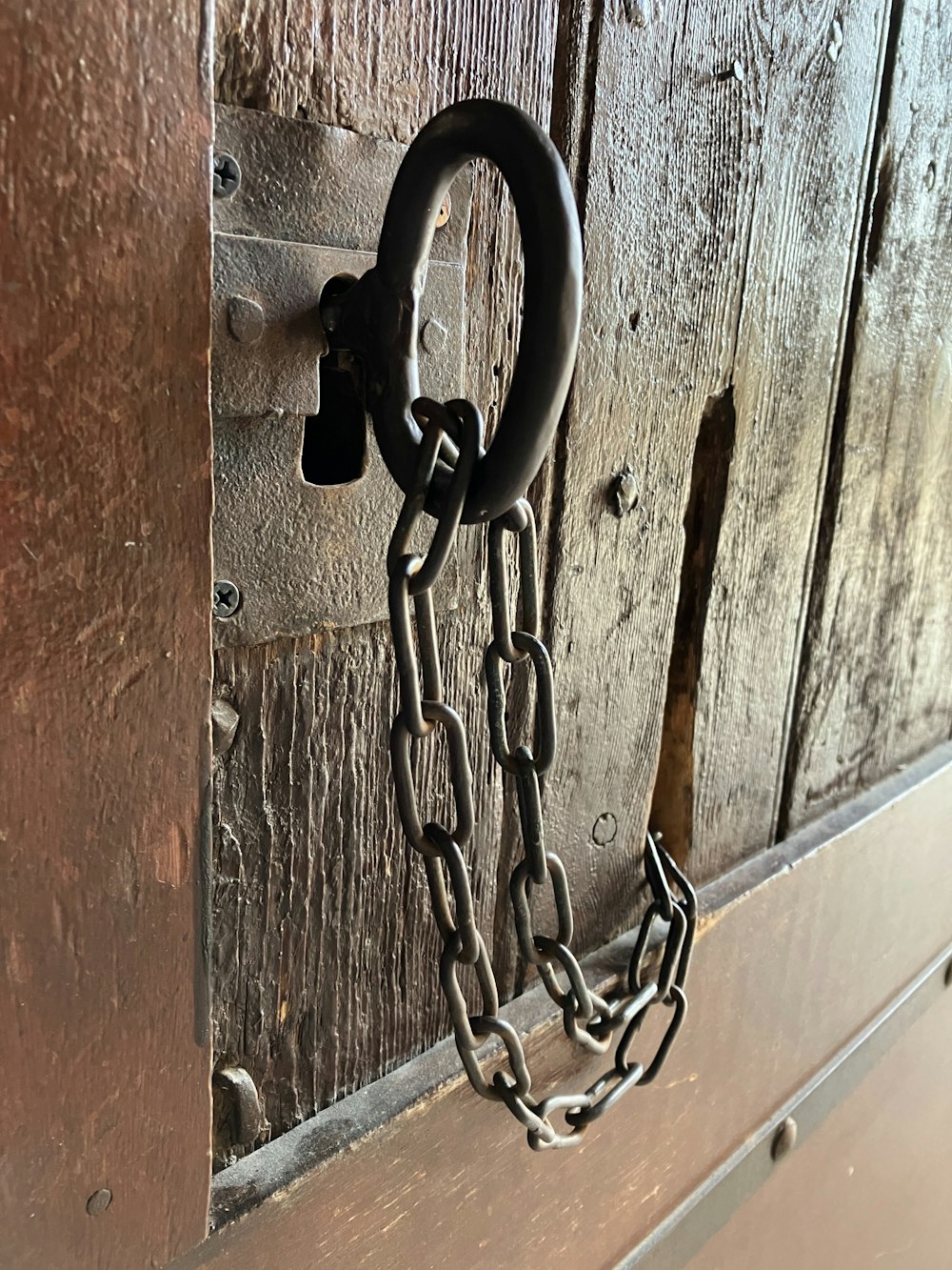 a metal chain hanging from a wooden door