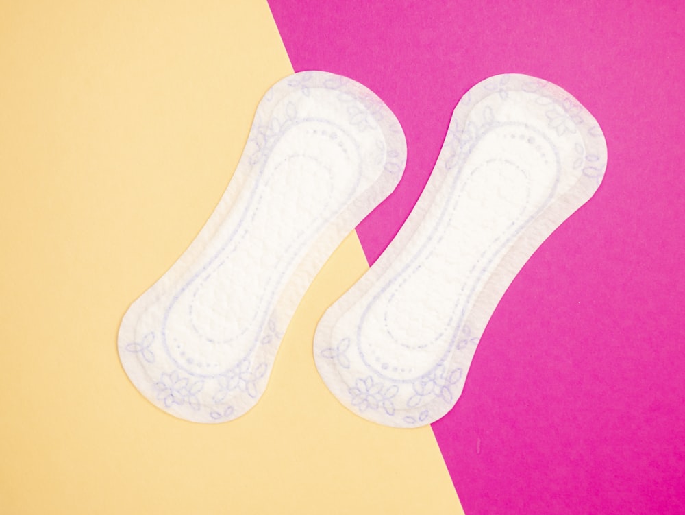 a pair of white socks sitting on top of a pink and yellow background