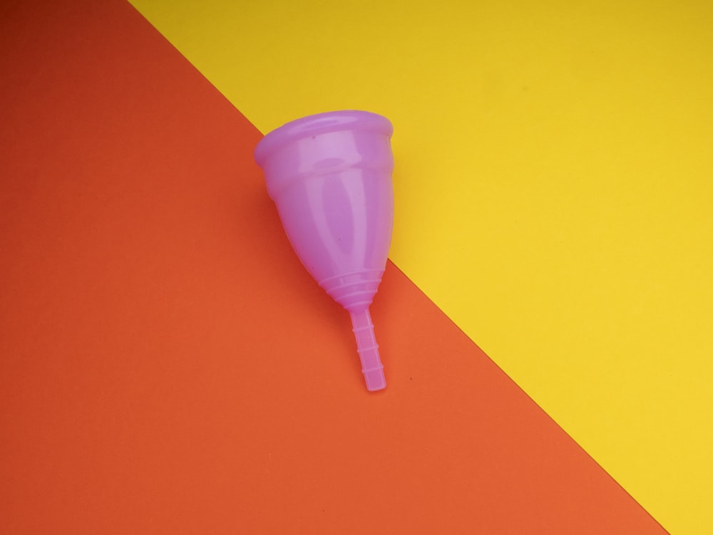 um copo de plástico sentado em cima de uma superfície colorida