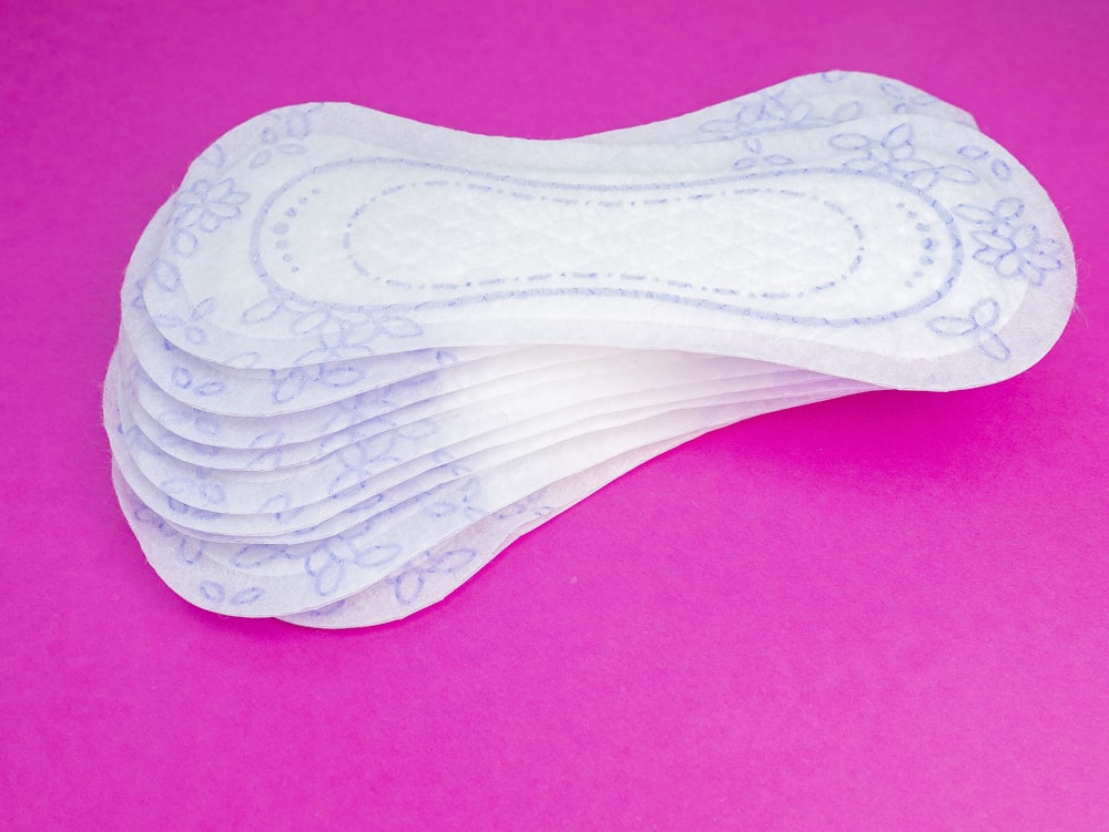 a stack of white pads sitting on top of a pink surface