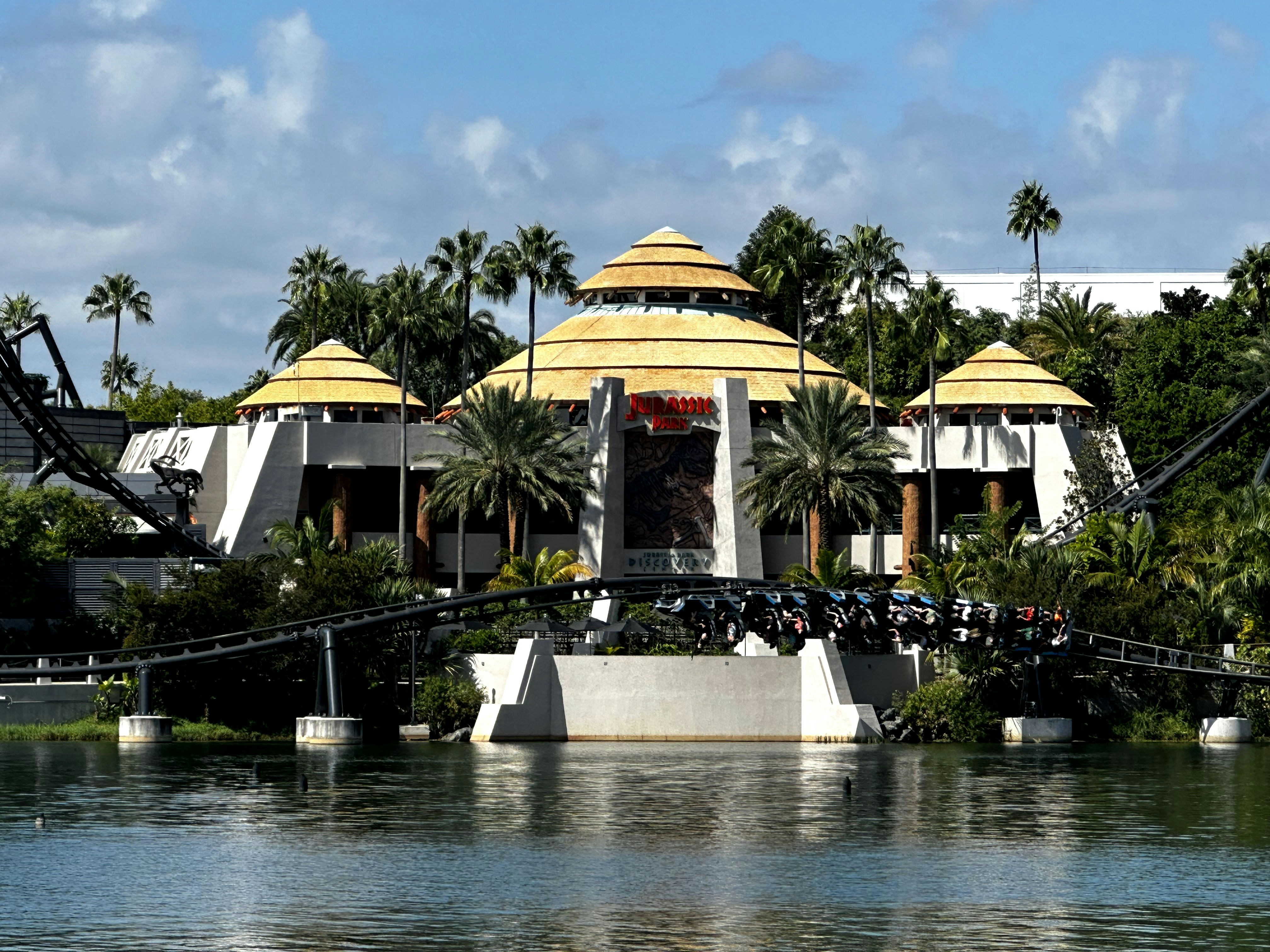 a large building with a yellow roof next to a body of water