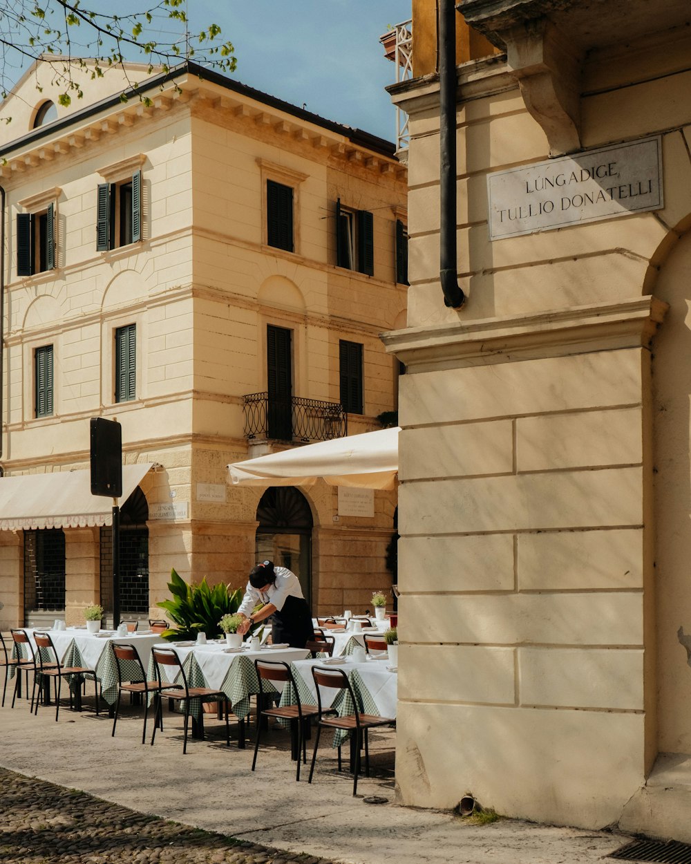 a couple of people sitting at a table in front of a building