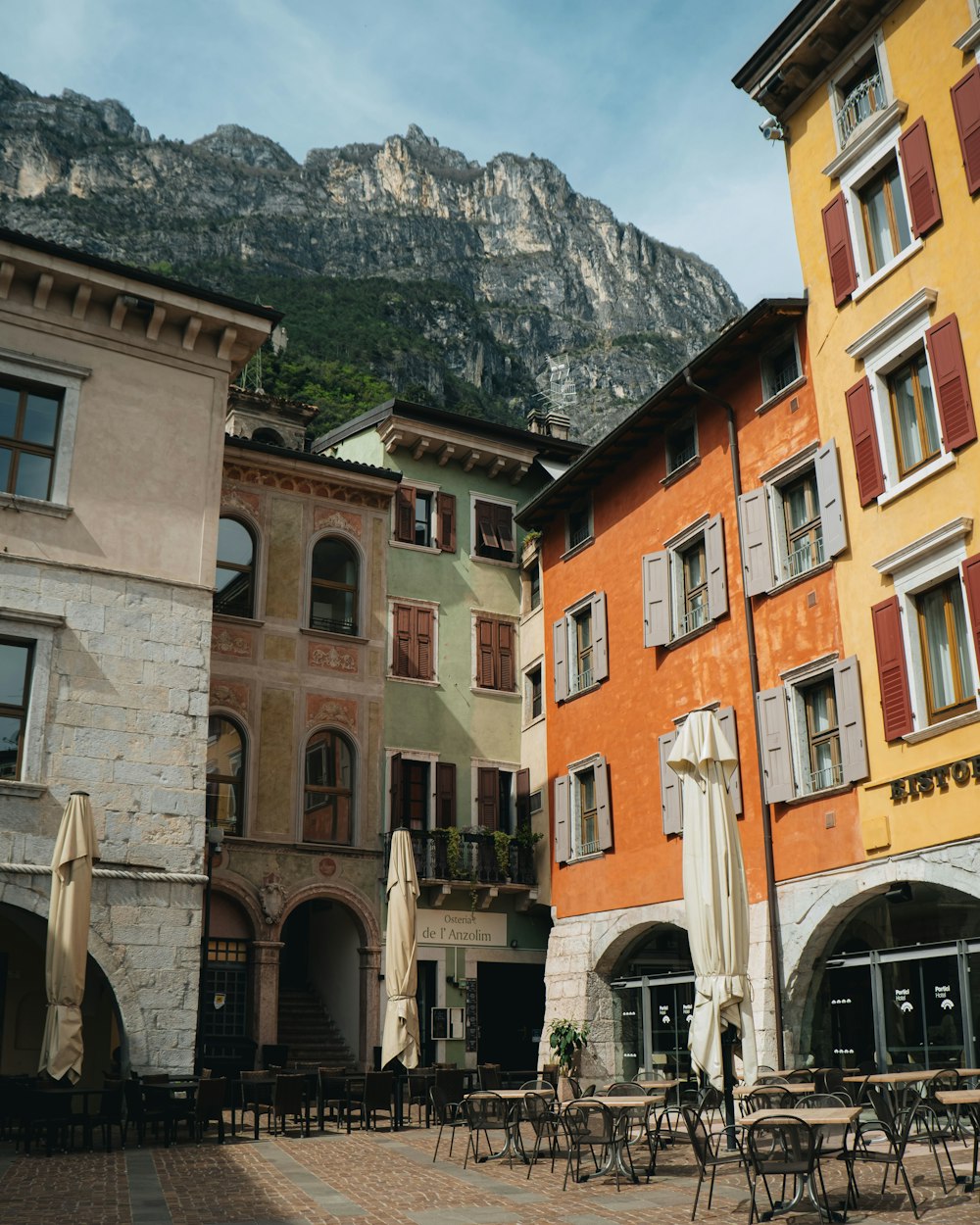 a row of buildings with tables and chairs in front of them