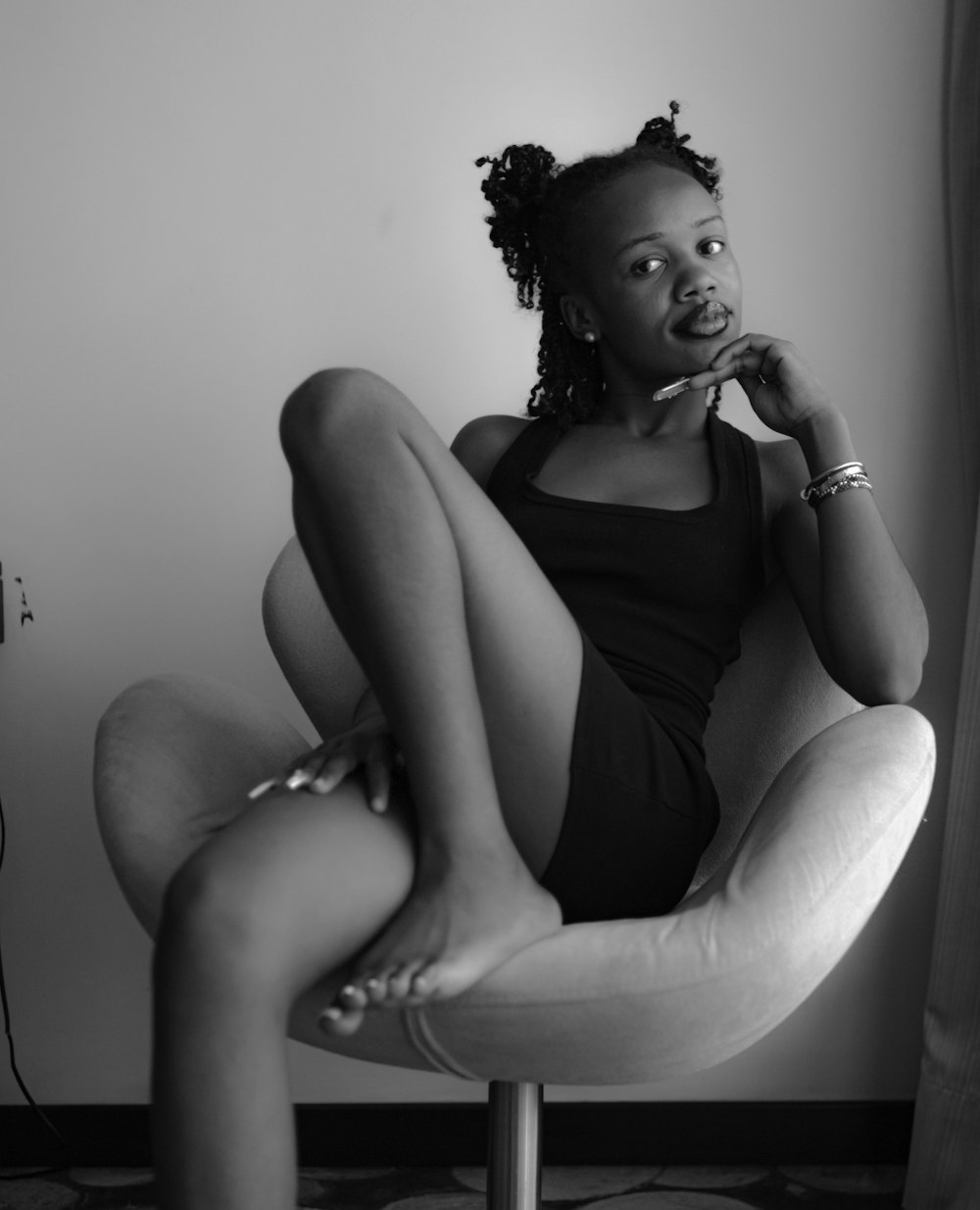 a black and white photo of a woman sitting on a chair