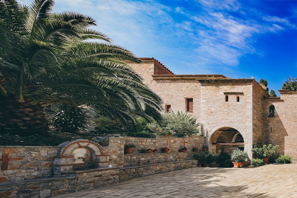 a stone building with a palm tree in front of it