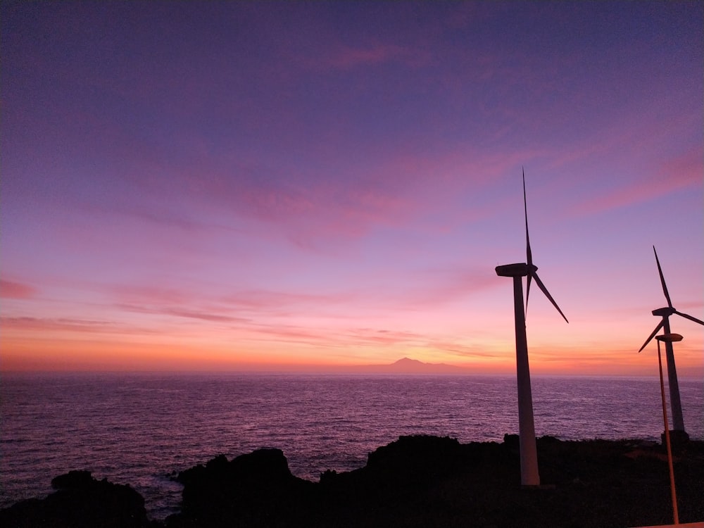 a couple of windmills that are by the water