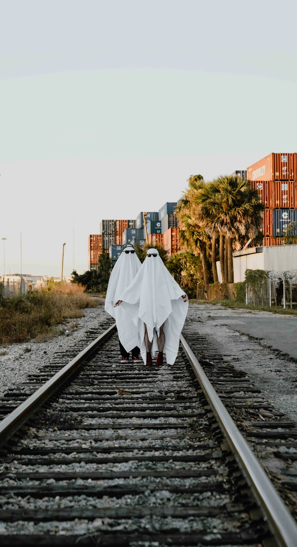 a person walking down a train track with a ghost costume on