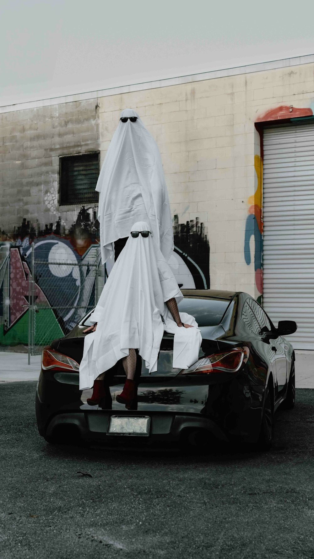 a person in a white dress standing on top of a car