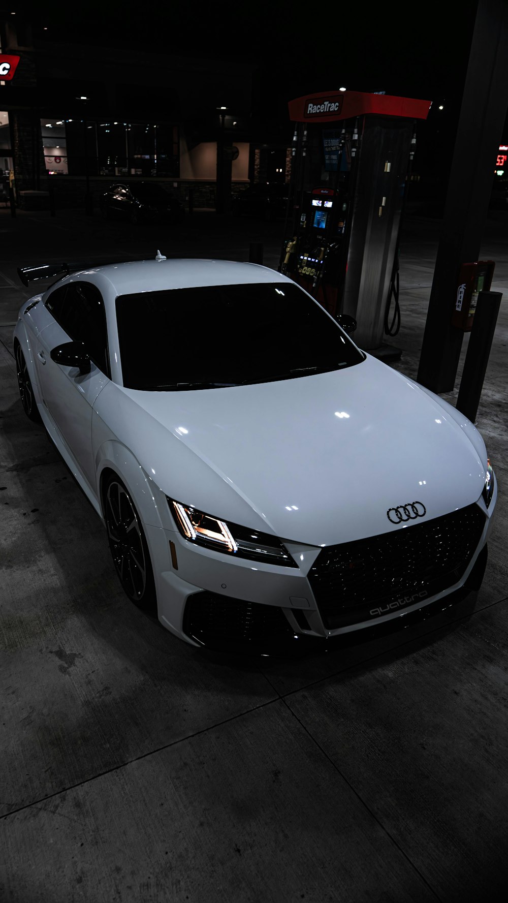 a white car parked in a parking lot at night