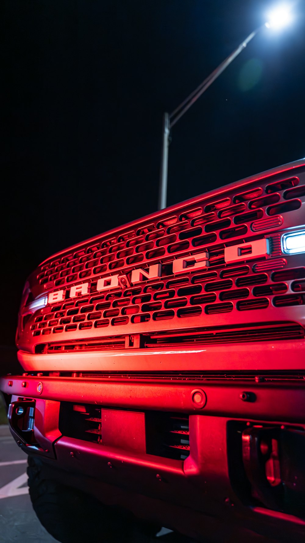a red truck parked in a parking lot at night