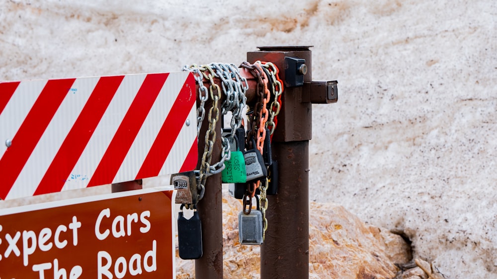 a red and white sign and some chains and a rock