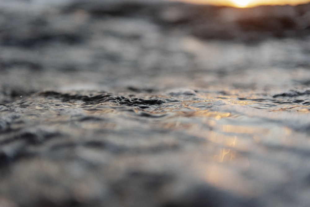 a blurry photo of water with a sun in the background