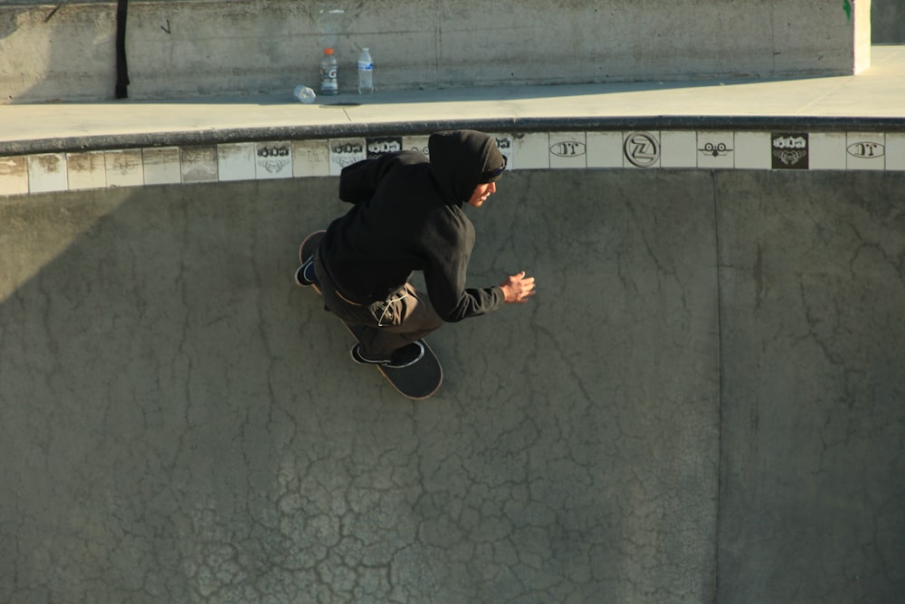 Un hombre montando una patineta por el costado de una rampa