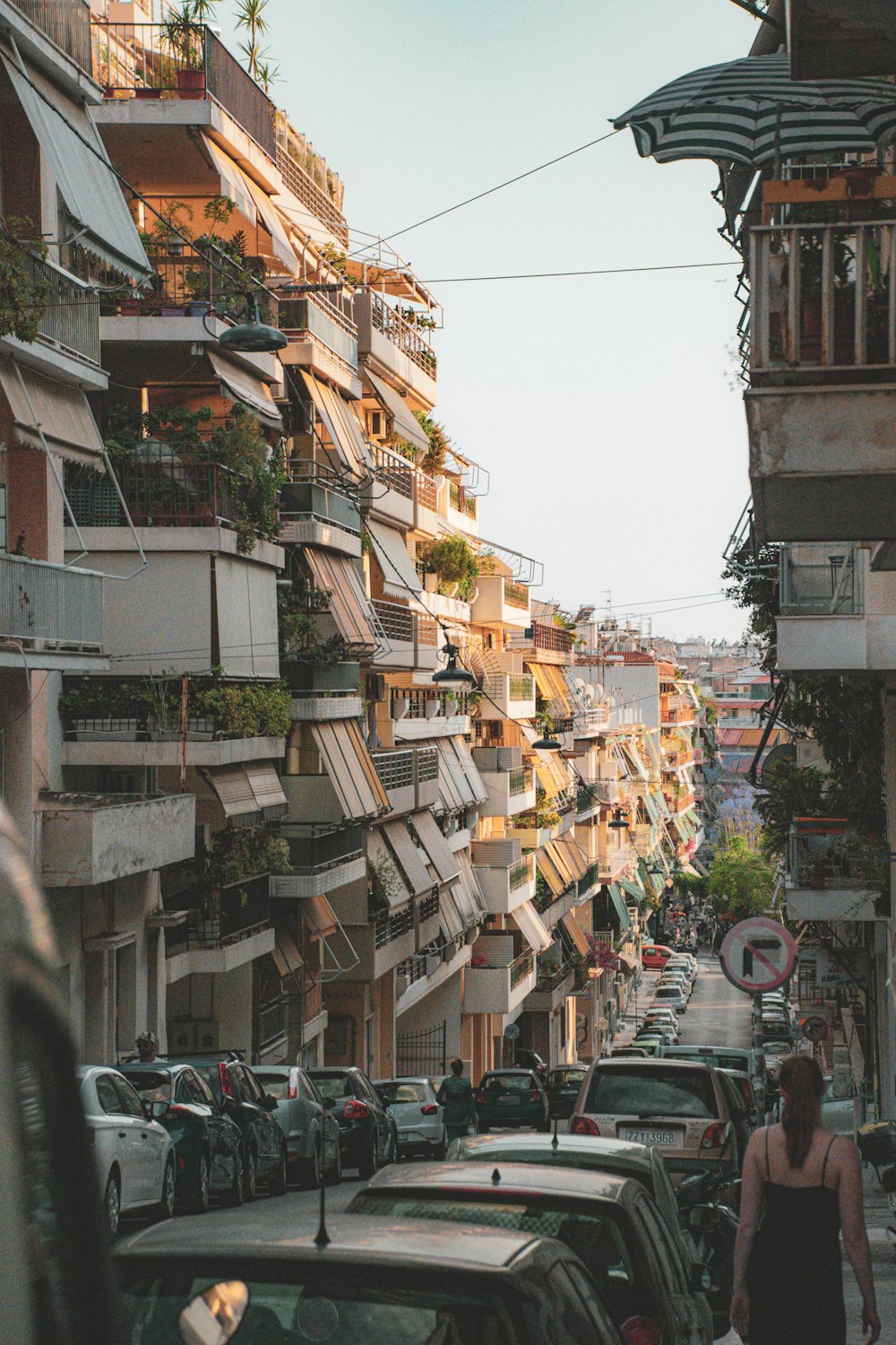 a woman walking down a street next to tall buildings