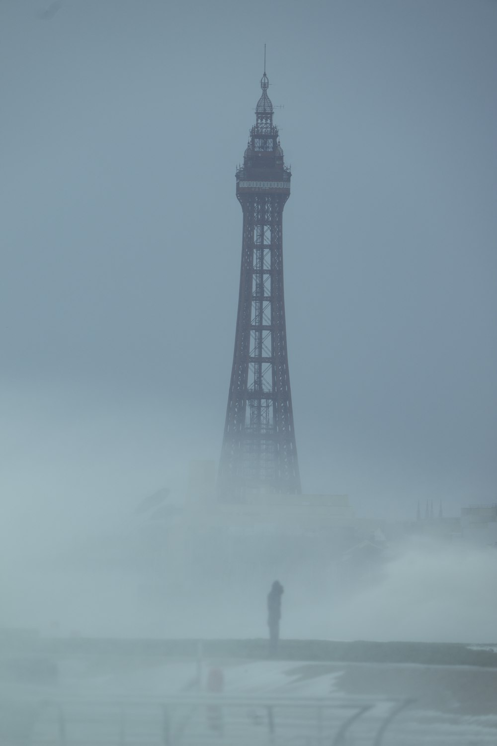 a person standing in front of a tall tower