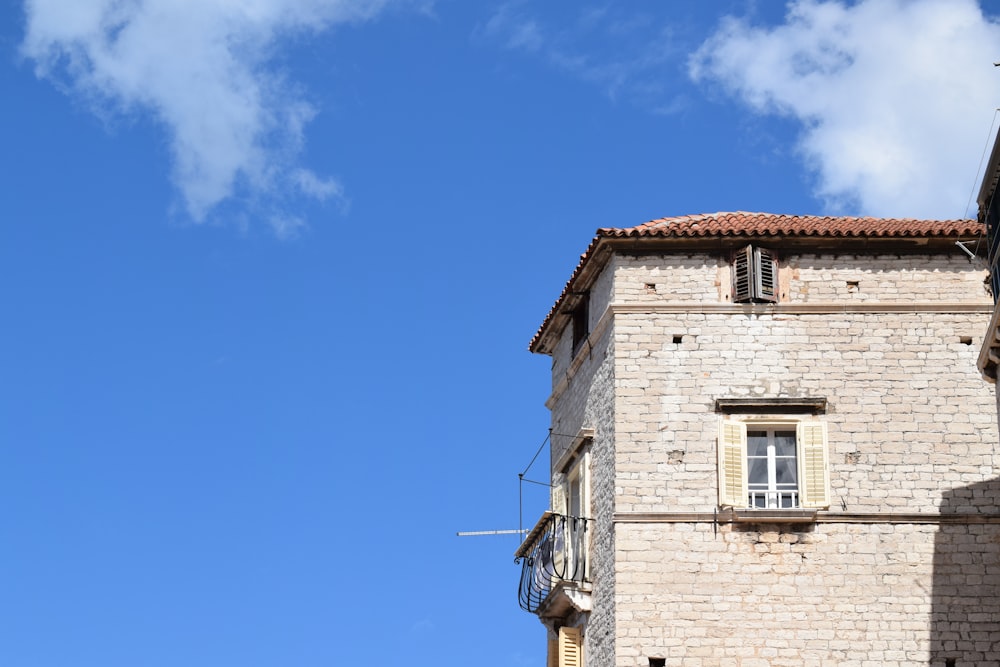 a tall brick building with a clock on it's side