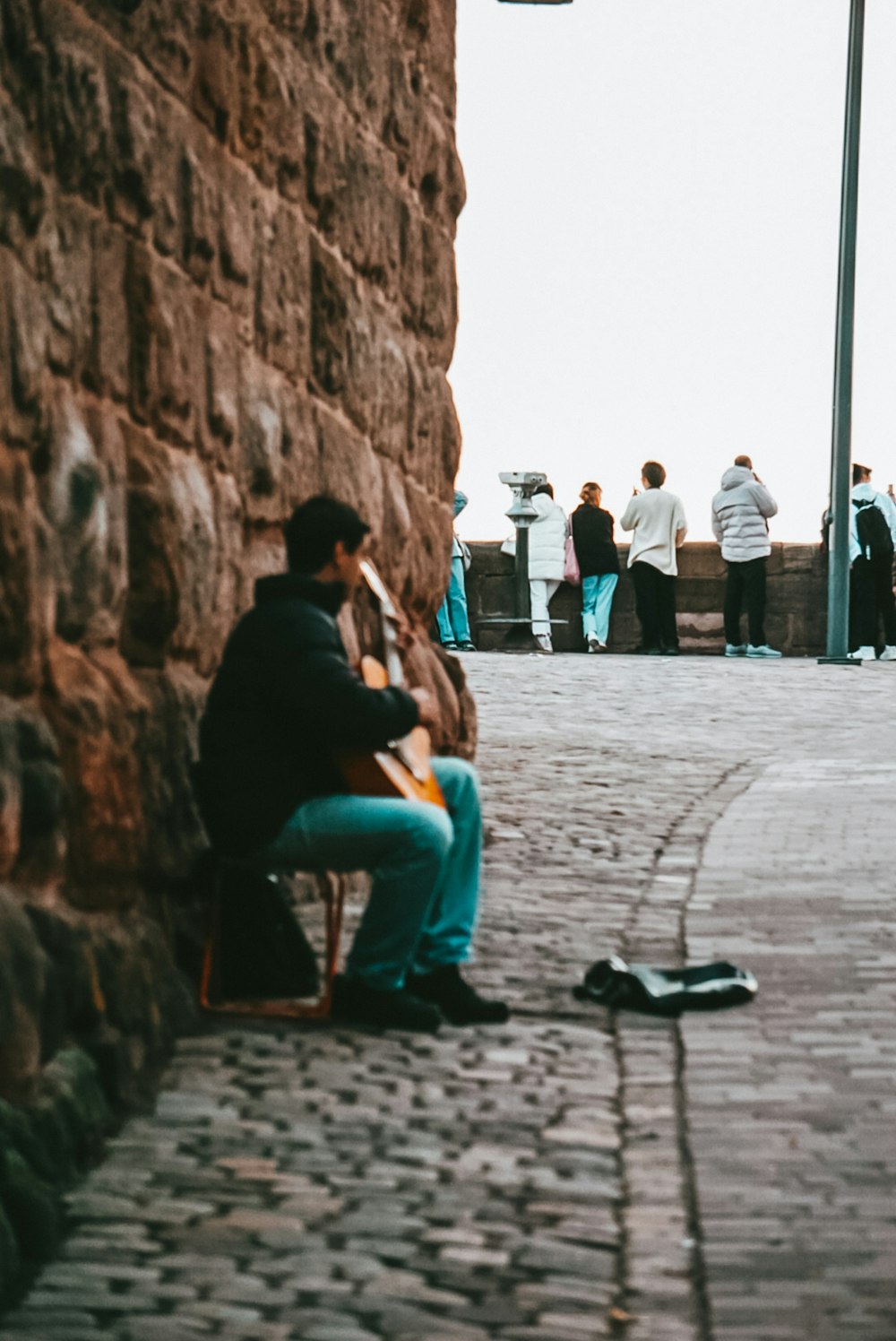 a man sitting on a bench next to a wall