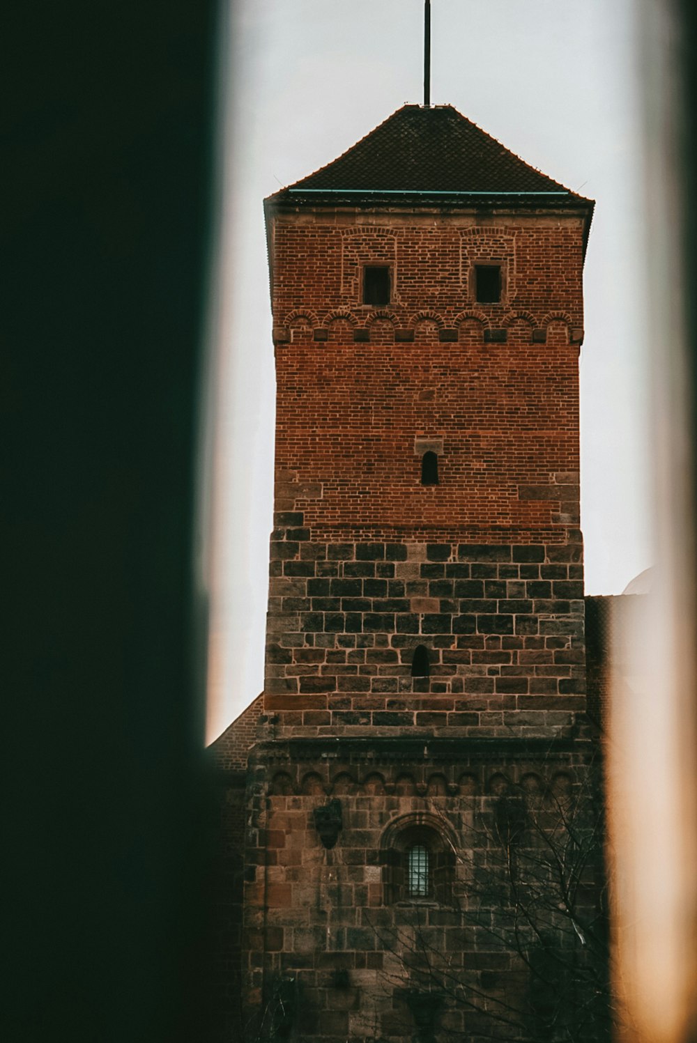 a tall brick tower with a cross on top