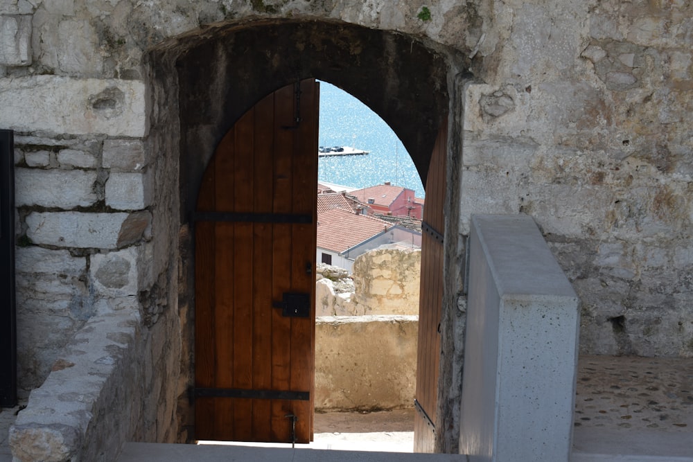 a doorway with a wooden door leading to the ocean