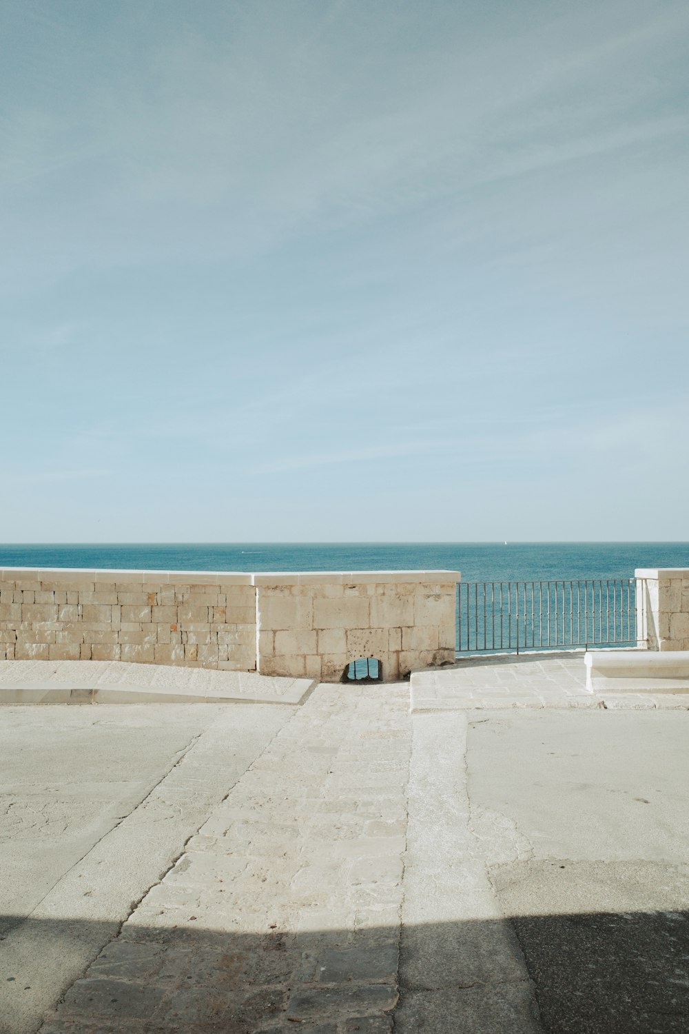 an empty parking lot next to a large body of water