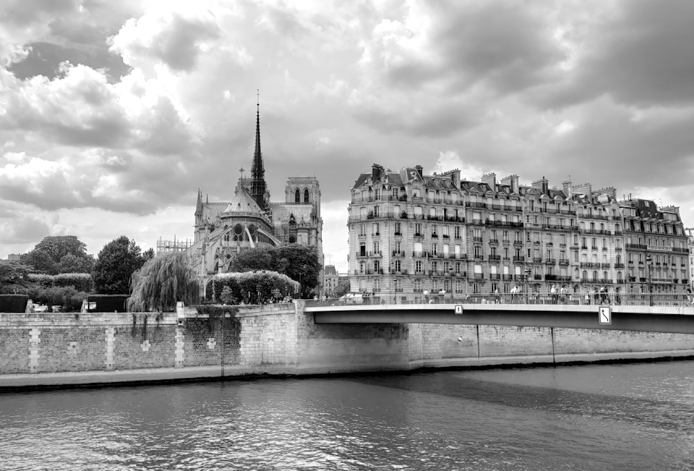 a black and white photo of a bridge and buildings