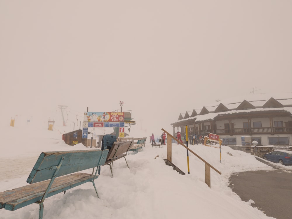 a wooden bench sitting on top of a snow covered slope