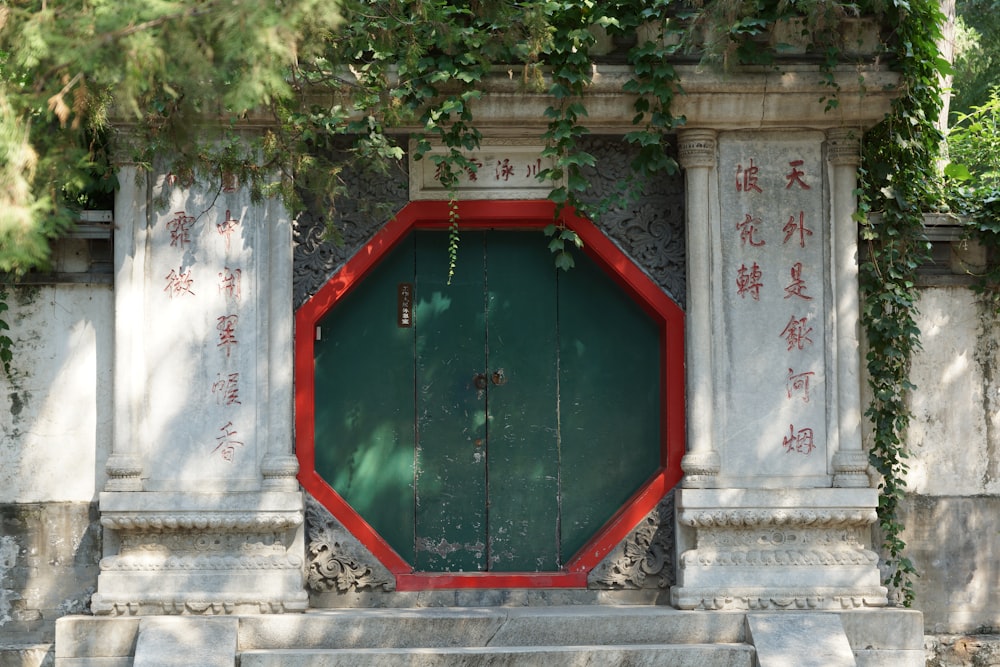 uma porta vermelha e verde em uma parede de pedra