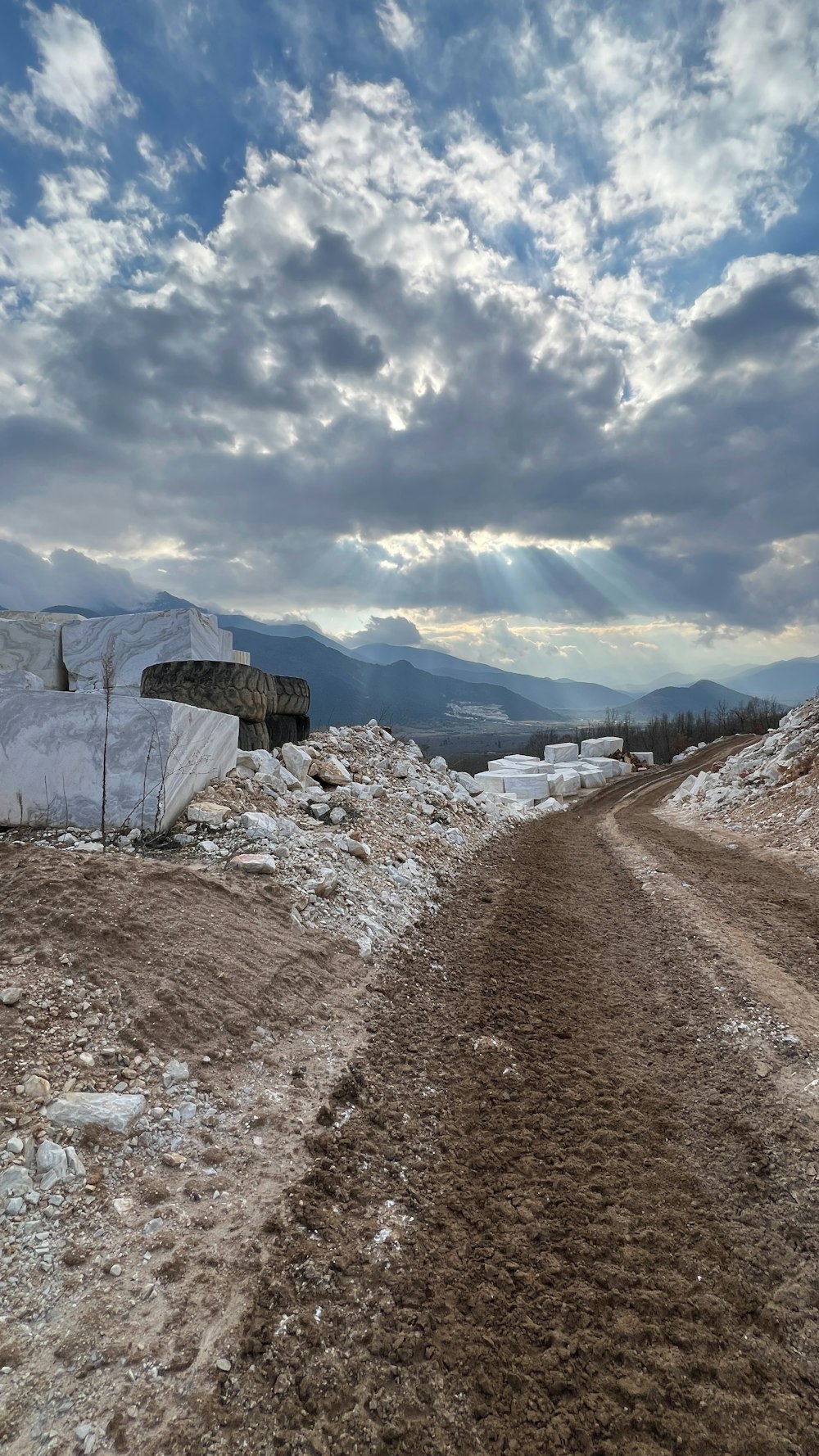 a dirt road with snow on the ground