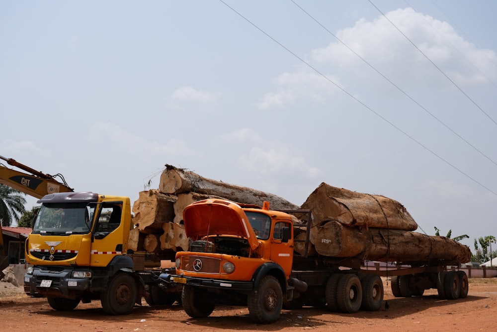 um grande caminhão transportando toras em uma estrada de terra