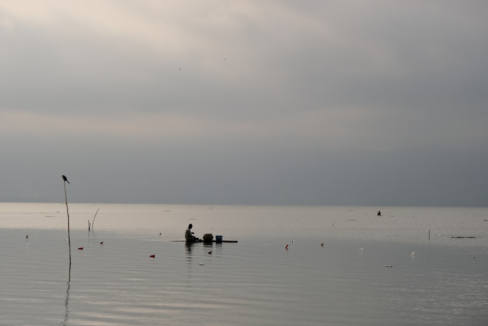 a person in a small boat on a large body of water