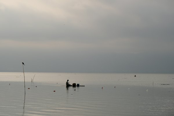A fisherman on a misty lake — Kumasi, Ghana