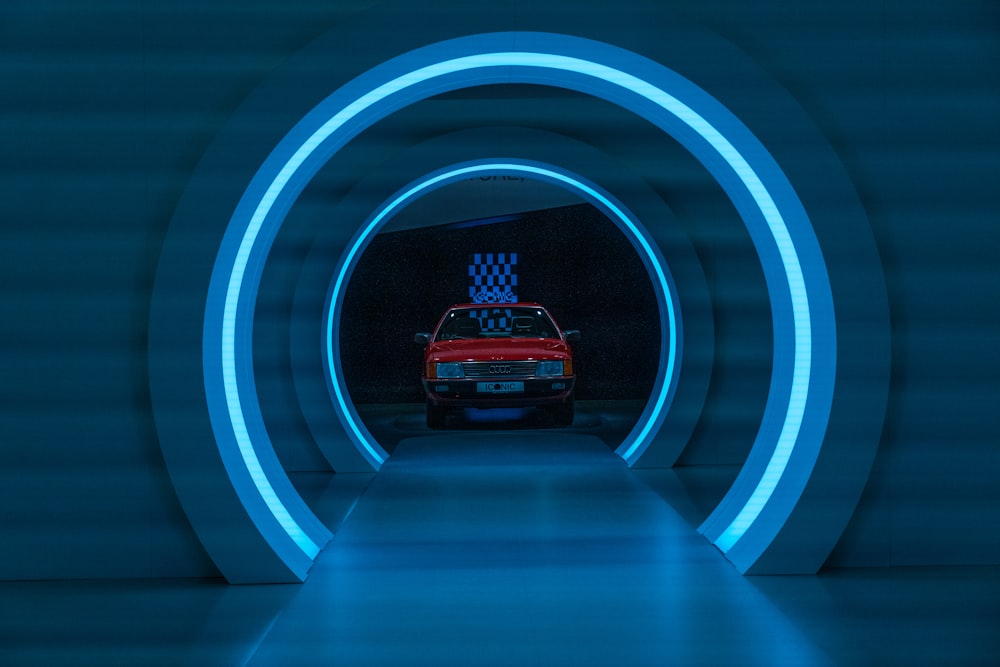 a car driving through a tunnel with blue lights