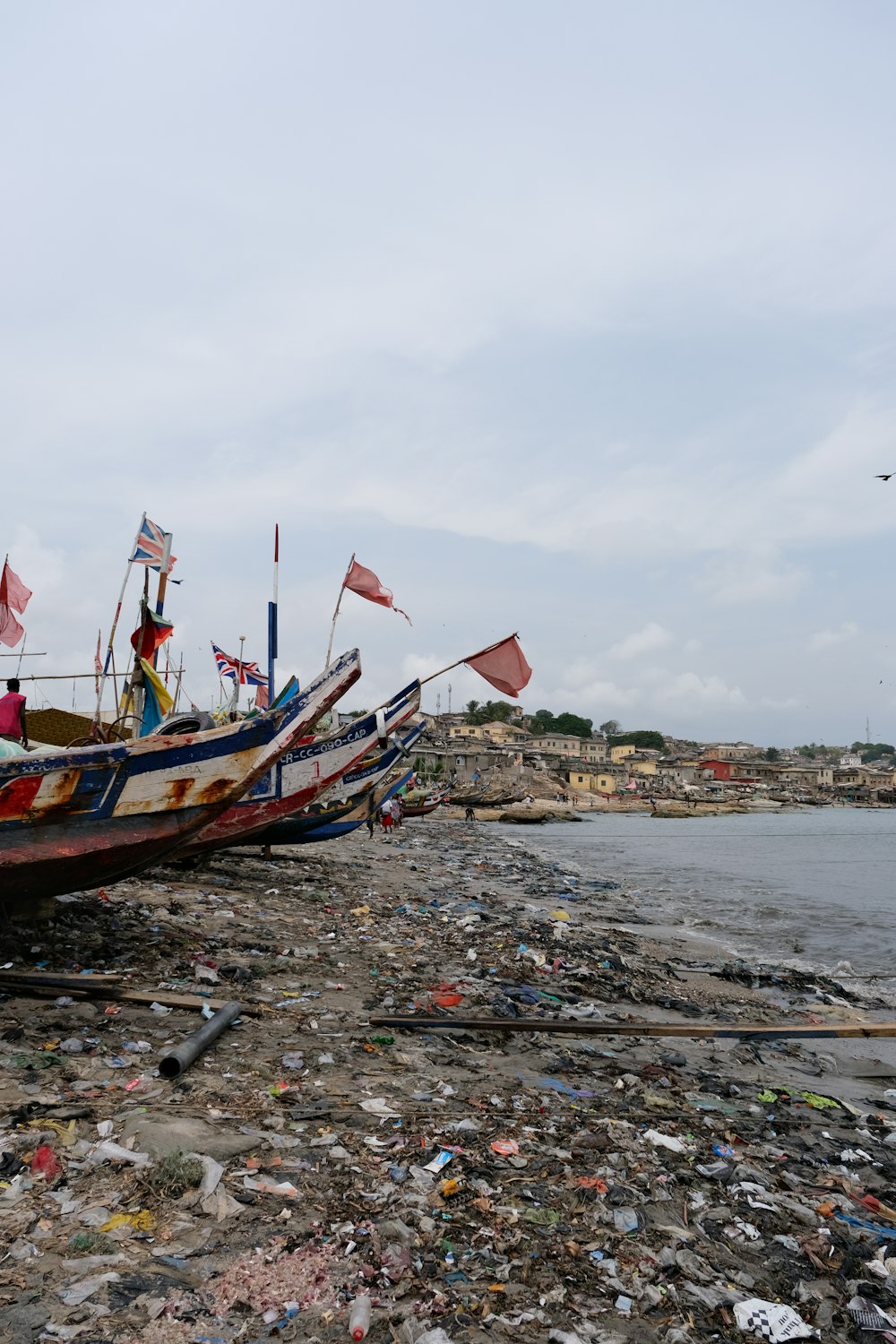 a boat sitting on top of a beach next to a body of water