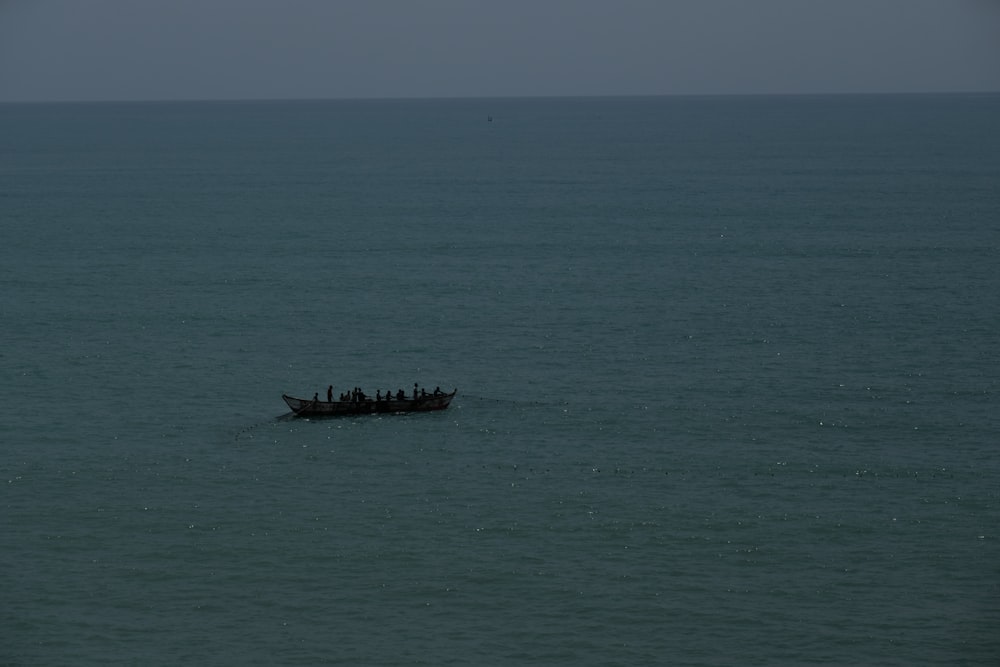 a group of people on a boat in the middle of the ocean