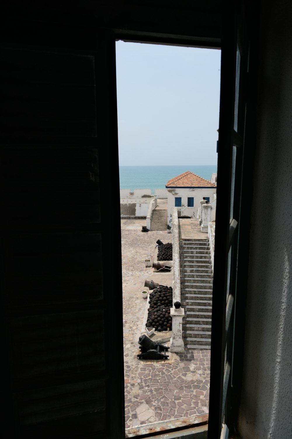 an open door leading to a building with a view of the ocean