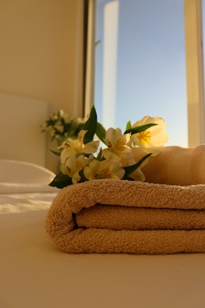 a stack of towels sitting on top of a bed