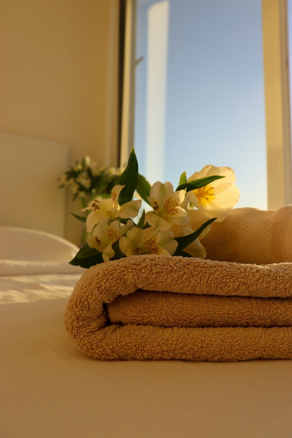 a stack of towels sitting on top of a bed