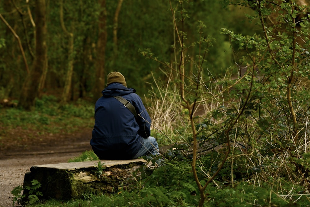 a person sitting on a bench in the woods