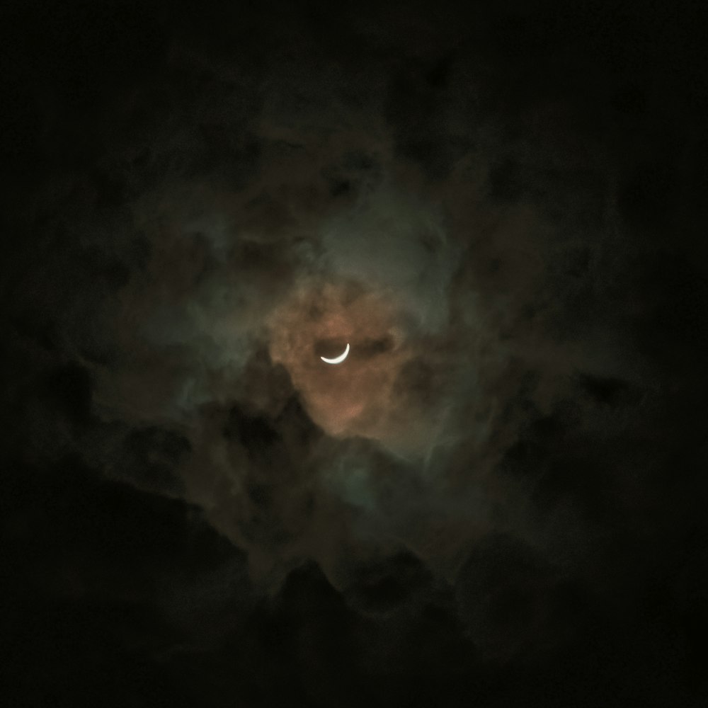 a partial solar eclipse seen through the clouds