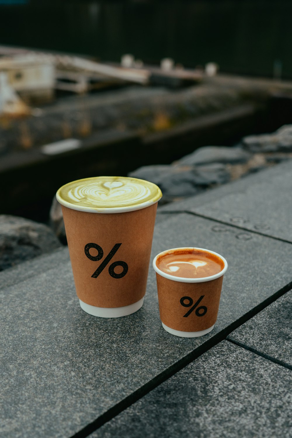 two cups of coffee sitting on a ledge