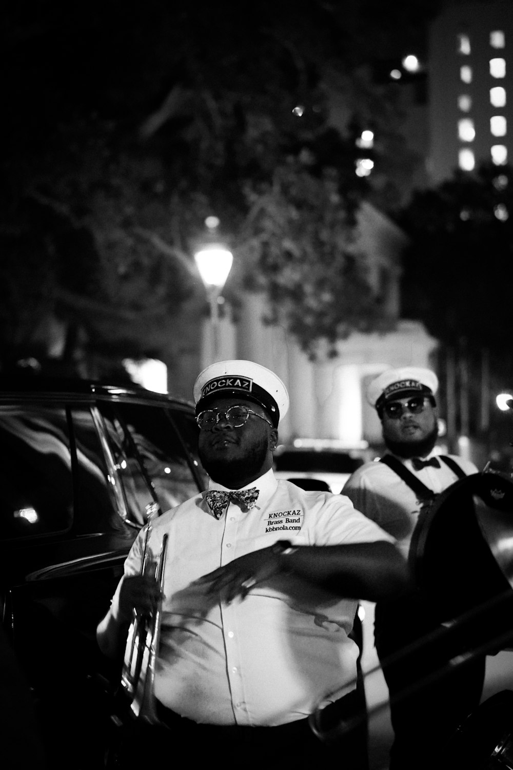 a couple of men standing next to each other in front of a car