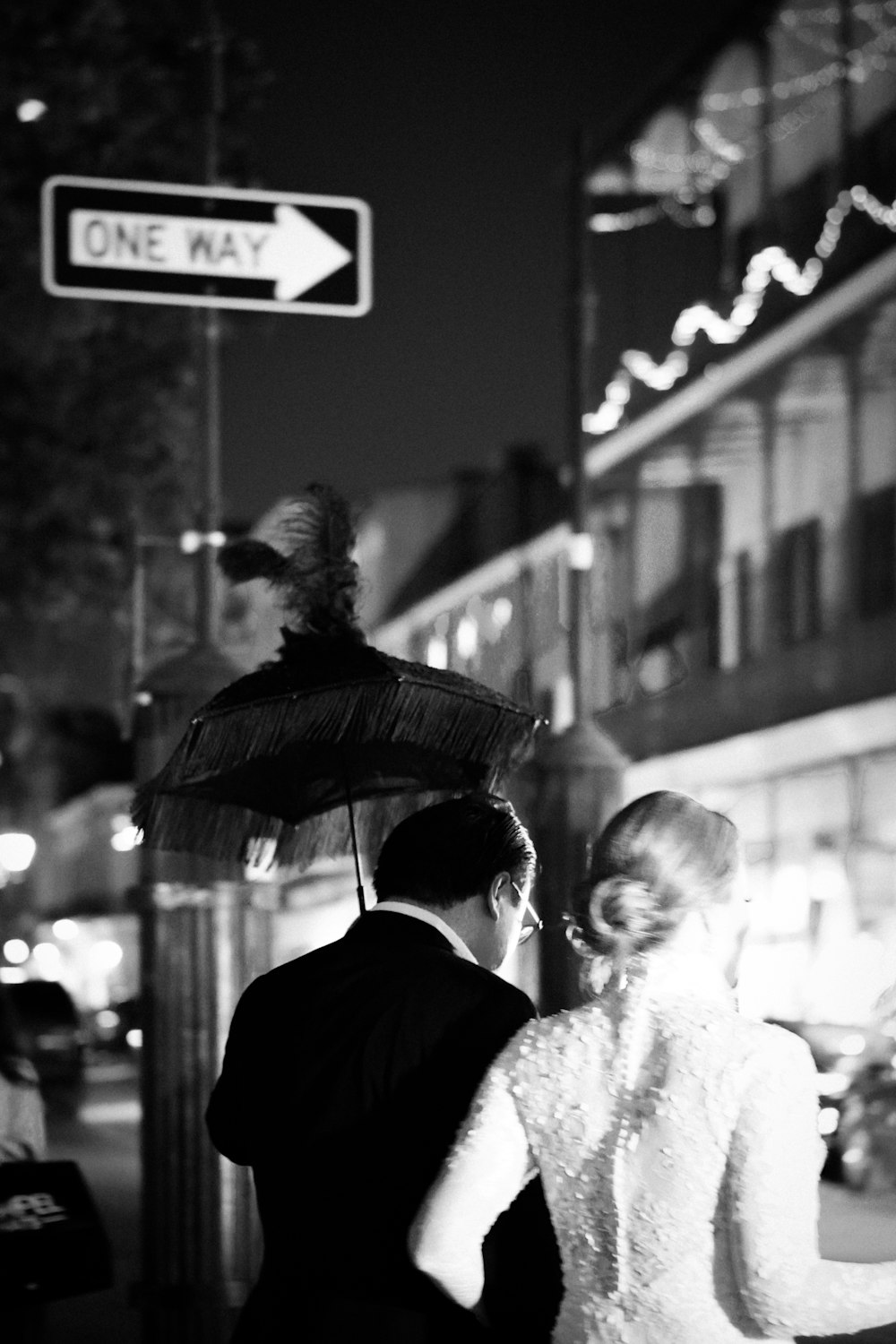 a man and woman walking down a street holding an umbrella