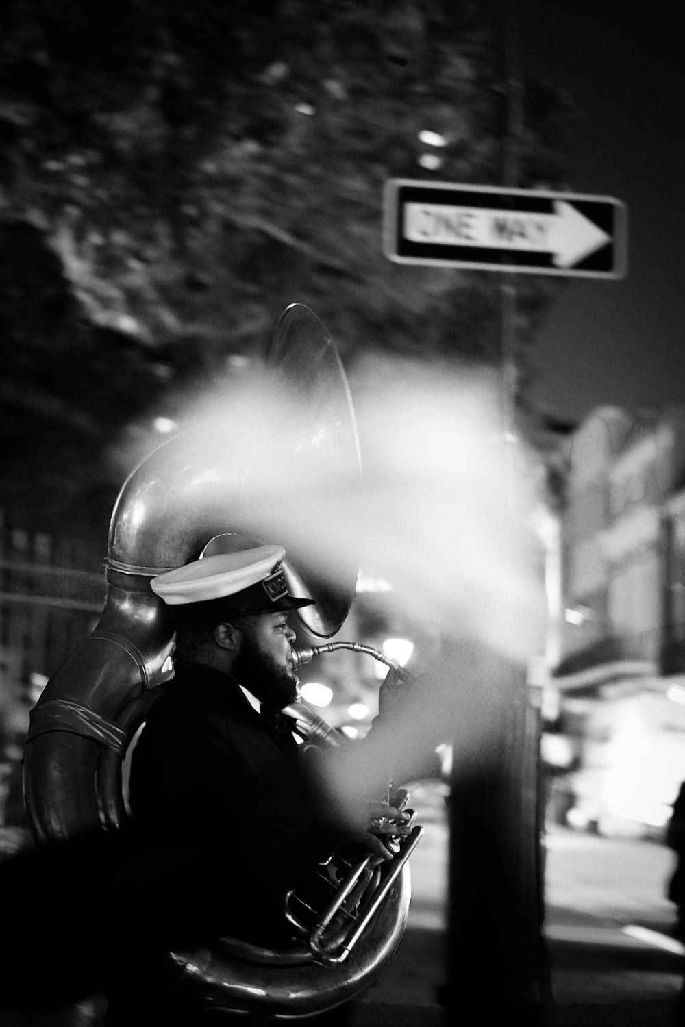 a man sitting on a bench next to a street sign