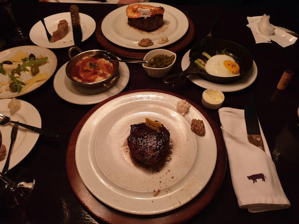 a table topped with plates of food and utensils