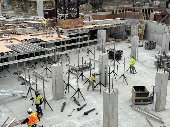 Workers preparing formwork on a construction site.